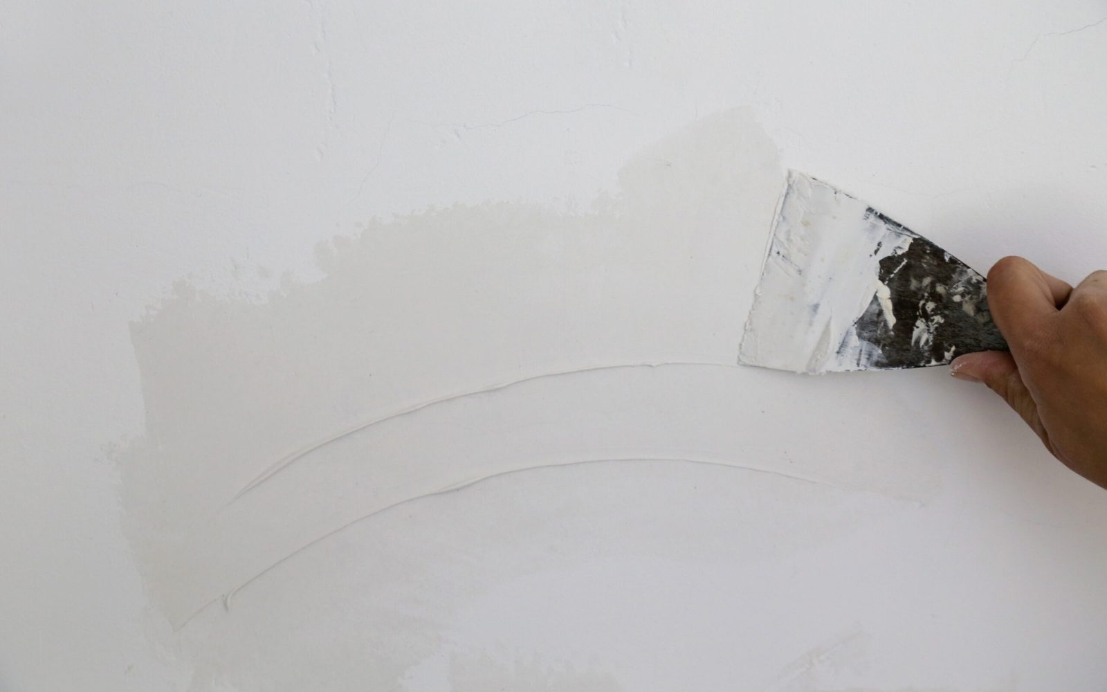 Plastering wall with putty-knife, close up image. Fixing wall su